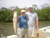 Red fish caught by adult couple on Marco Island Bay aboard Fins n Grins charter fishing boat